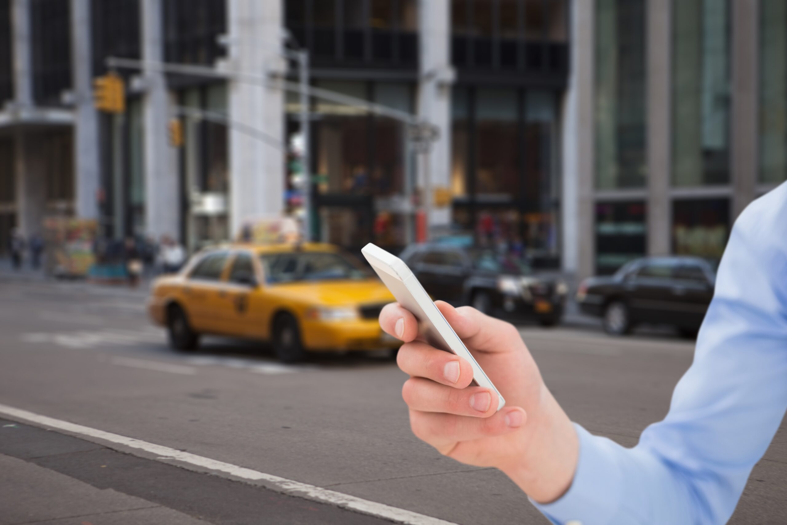 Composite image of hand holding smartphone with street background